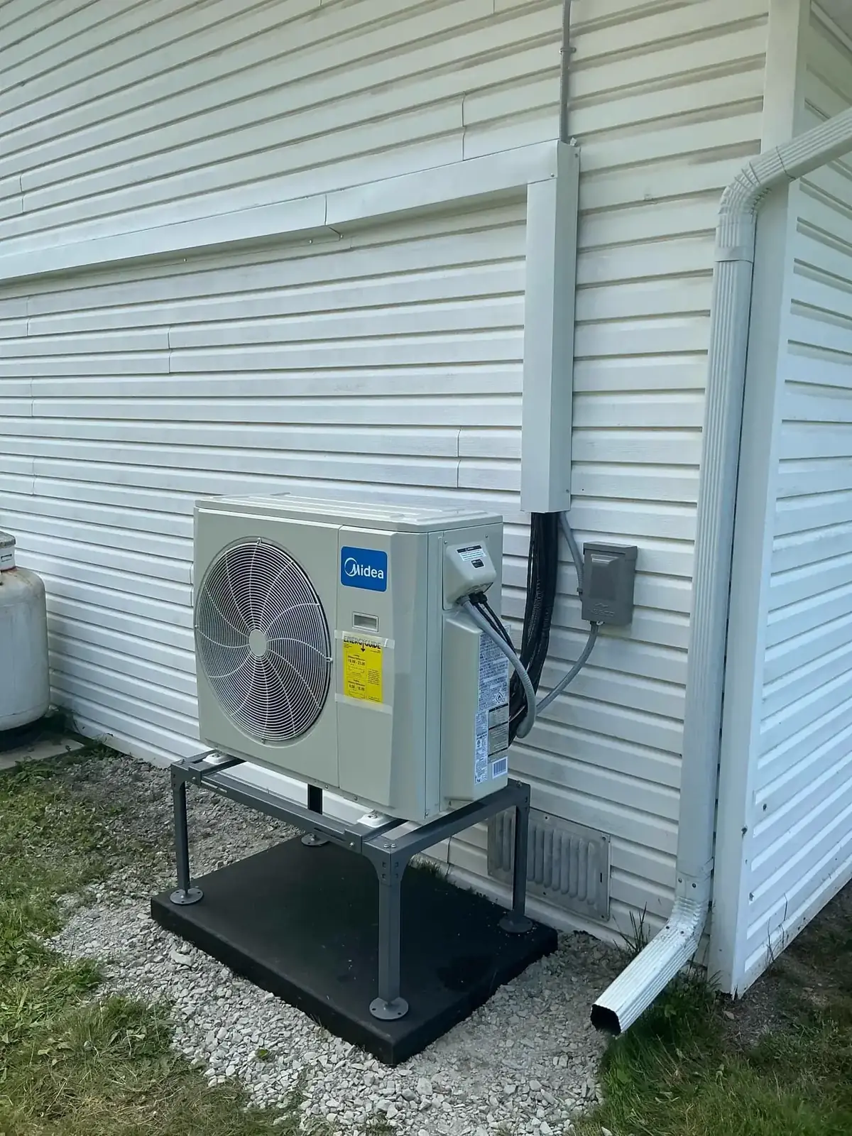 Large outdoor heat pump unit installed on a raised stand