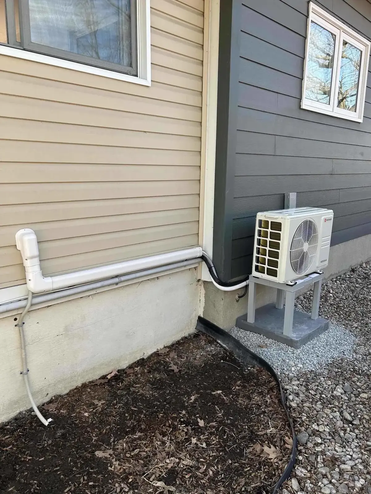Outdoor heat pump unit with the line set routed along a wall